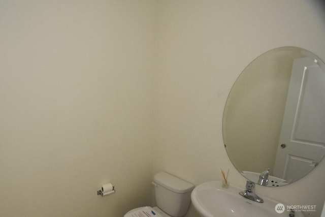 half bath featuring a sink and toilet