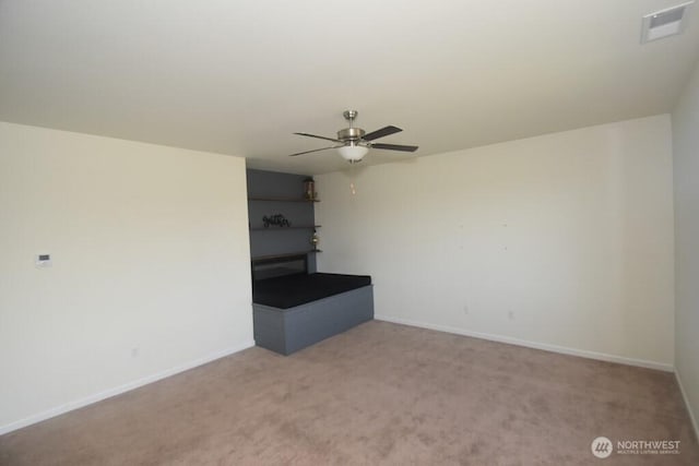 unfurnished living room with carpet floors, ceiling fan, baseboards, and visible vents