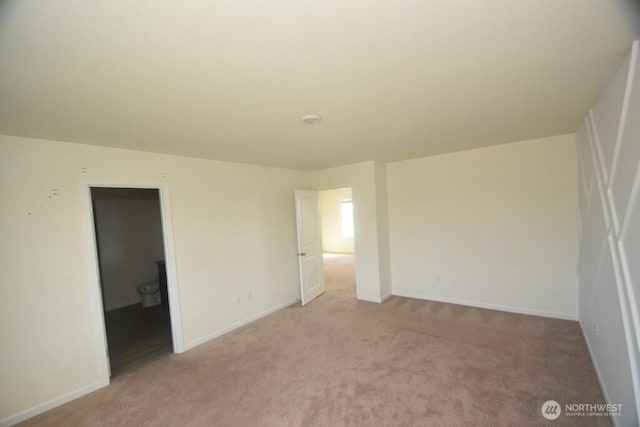 unfurnished bedroom featuring baseboards and light colored carpet