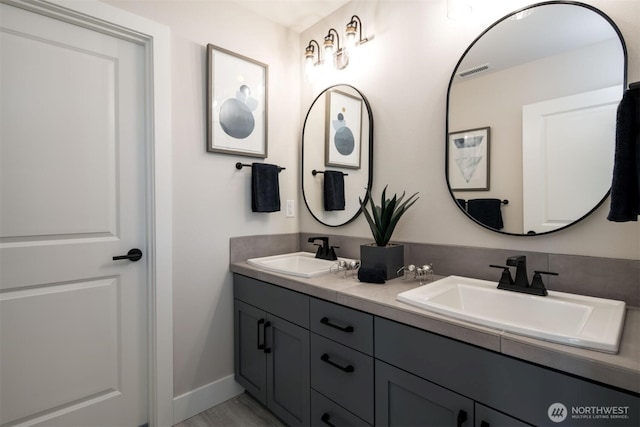 9319 129th Street Ct NW, Gig Harbor, WA 98329 - bathroom featuring double vanity, a sink, baseboards, and visible vents
