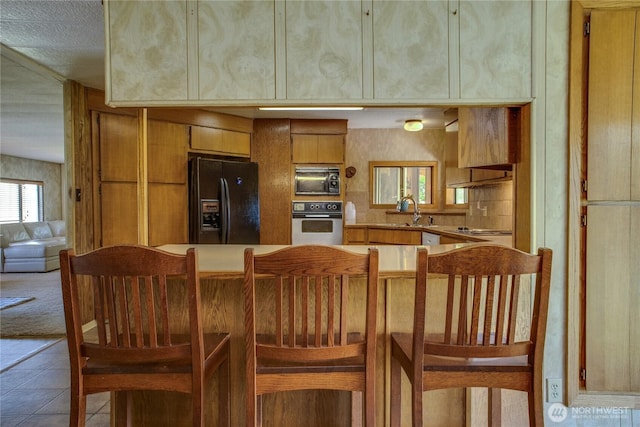 153 Biscuit Ridge Rd, Dixie, WA 99329 - kitchen with stainless steel oven, black fridge, built in microwave, brown cabinets, and cooktop