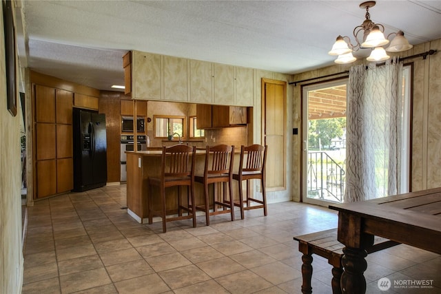 153 Biscuit Ridge Rd, Dixie, WA 99329 - kitchen with appliances with stainless steel finishes, a chandelier, light tile patterned floors, a breakfast bar, and decorative light fixtures