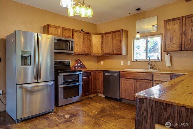 153 Biscuit Ridge Rd, Dixie, WA 99329 - kitchen featuring stainless steel appliances, a sink, brown cabinets, and hanging light fixtures