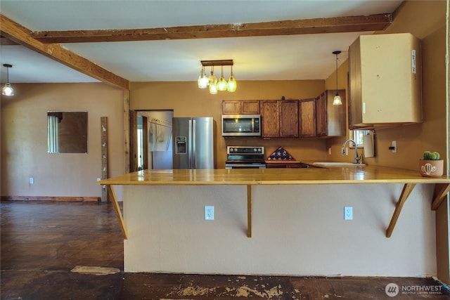 153 Biscuit Ridge Rd, Dixie, WA 99329 - kitchen with appliances with stainless steel finishes, a sink, brown cabinets, a peninsula, and pendant lighting