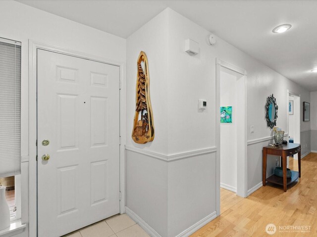 foyer entrance featuring baseboards and light wood-type flooring