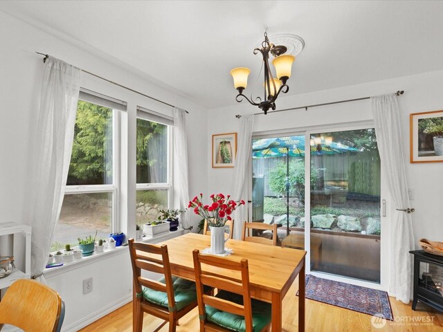 dining room featuring light wood-type flooring and a chandelier