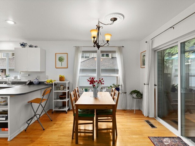 dining area featuring visible vents, plenty of natural light, and light wood-type flooring