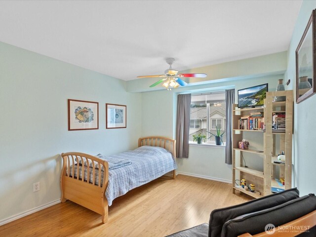 bedroom featuring baseboards, a ceiling fan, and wood finished floors