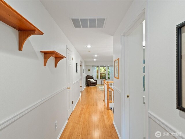corridor with recessed lighting, an upstairs landing, light wood-type flooring, and visible vents