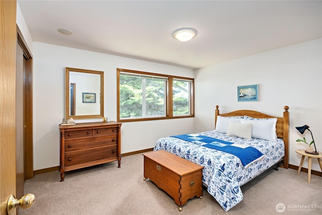 bedroom with baseboards, light carpet, and a closet