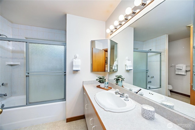full bath with vanity, baseboards, combined bath / shower with glass door, and toilet