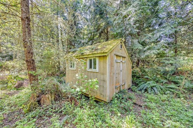 view of shed with a wooded view