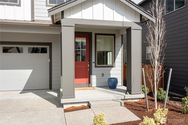 entrance to property with board and batten siding and concrete driveway