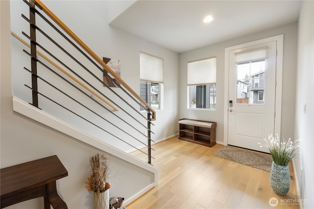 foyer entrance with light wood-type flooring, recessed lighting, stairs, and baseboards