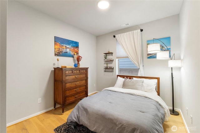 bedroom featuring light wood-style floors, baseboards, and visible vents