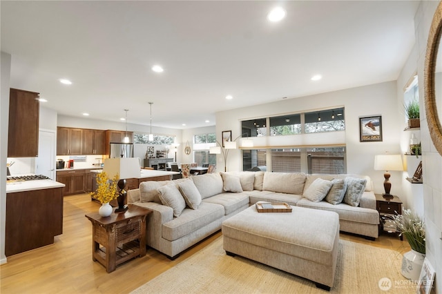 living area with light wood-type flooring and recessed lighting