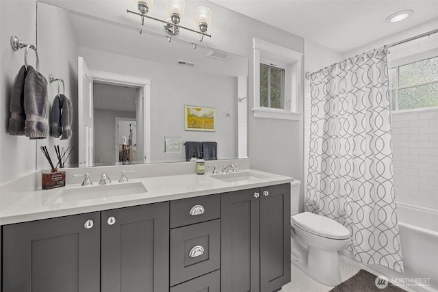 bathroom featuring a sink, toilet, double vanity, and visible vents