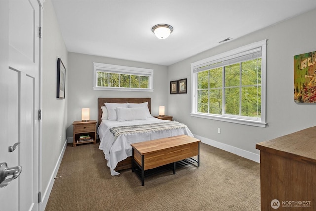bedroom featuring baseboards, dark carpet, and visible vents