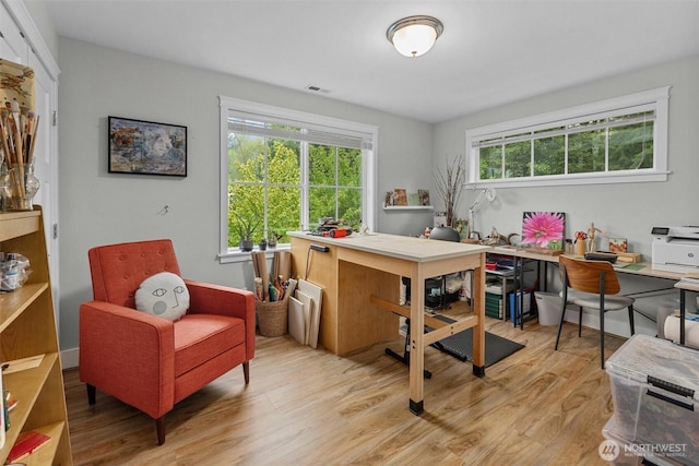 office with light wood-style floors and visible vents