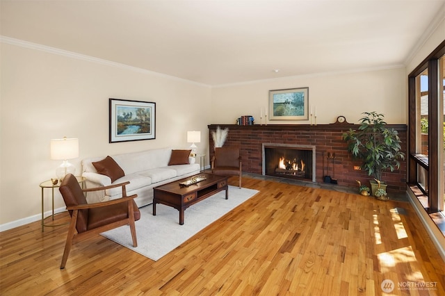 living area featuring crown molding, baseboards, wood finished floors, and a fireplace