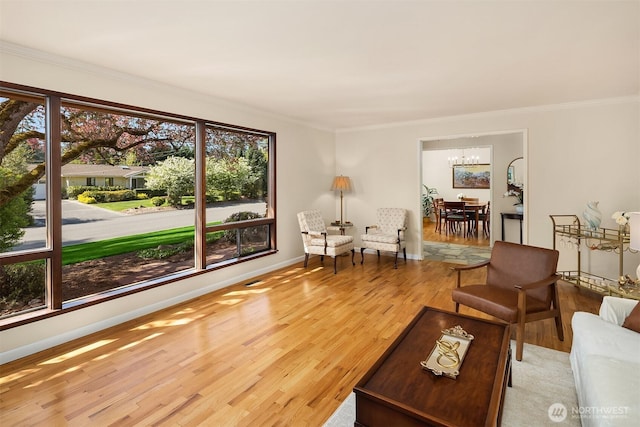 living area with crown molding, baseboards, a healthy amount of sunlight, and wood finished floors