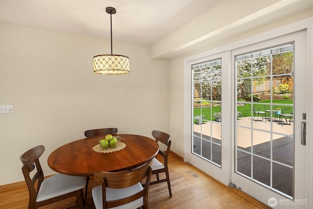 dining area with baseboards, visible vents, and light wood-type flooring