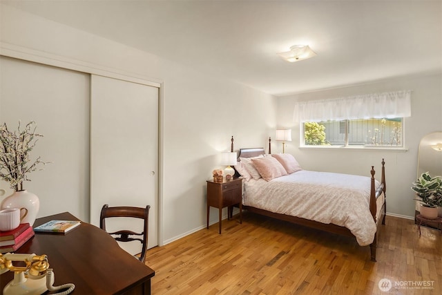 bedroom featuring a closet, light wood finished floors, and baseboards