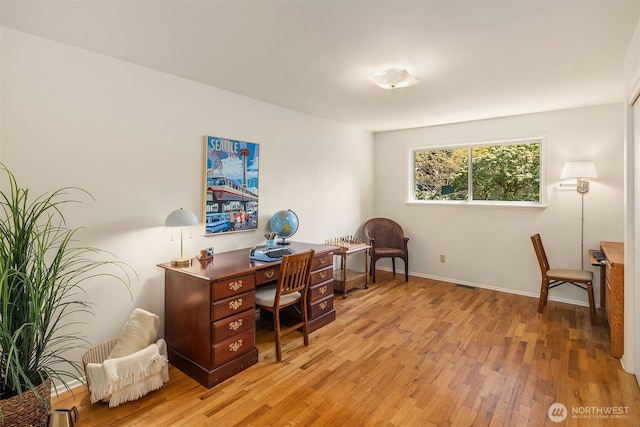 office area featuring baseboards, light wood finished floors, and visible vents