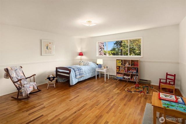 bedroom featuring a baseboard heating unit and wood finished floors
