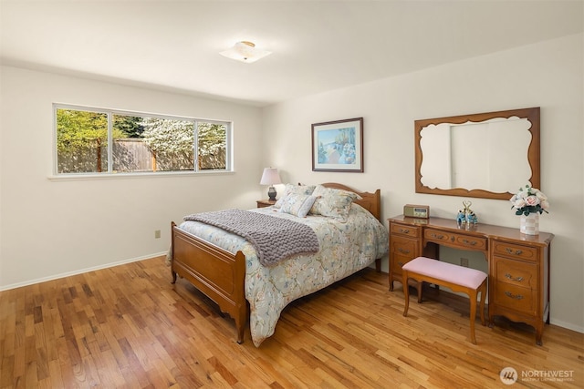 bedroom with baseboards and light wood finished floors