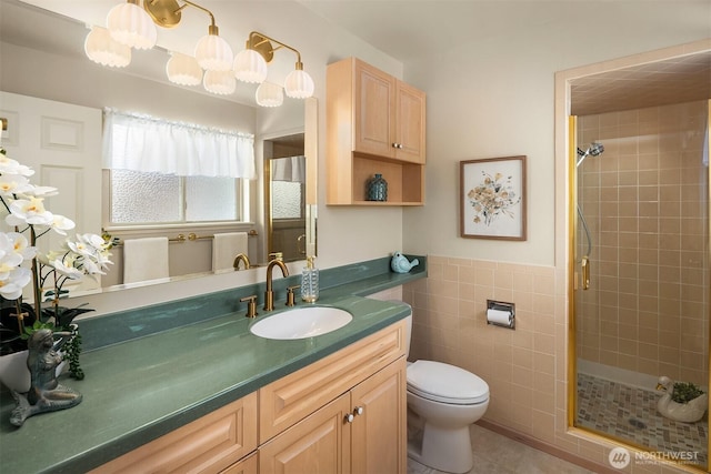 bathroom featuring tile patterned flooring, vanity, toilet, tile walls, and a shower stall