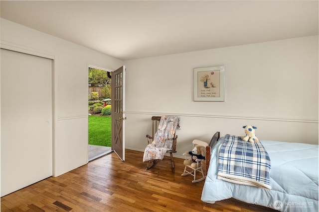 bedroom with access to outside and wood finished floors
