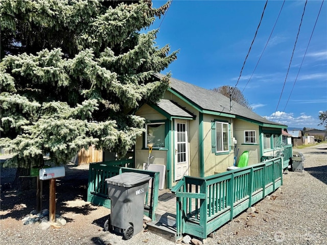 view of home's exterior featuring a shingled roof and fence