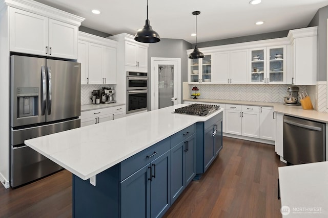 kitchen with dark wood finished floors, tasteful backsplash, stainless steel appliances, and blue cabinetry