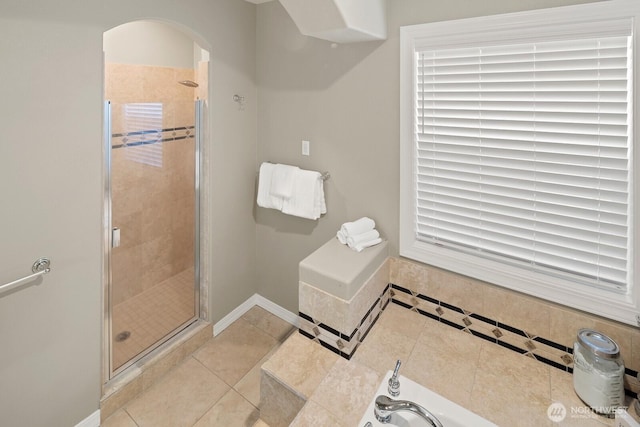 full bath with baseboards, tile patterned flooring, and a shower stall