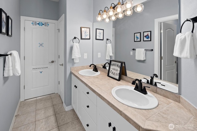 bathroom with baseboards, a sink, and tile patterned floors