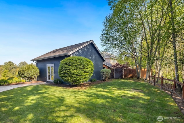 view of home's exterior featuring a yard, fence, and french doors