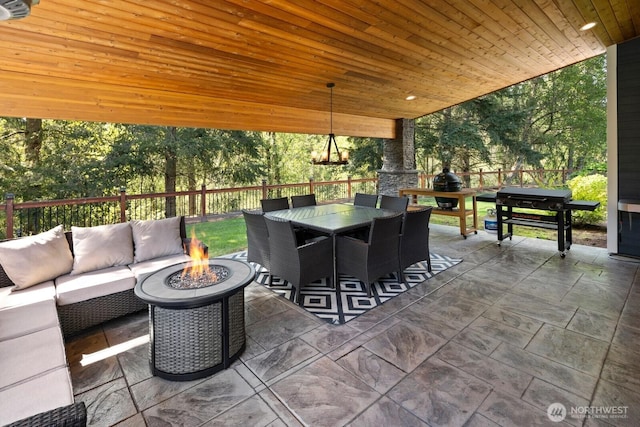 view of patio / terrace featuring fence, an outdoor living space with a fire pit, outdoor dining area, and grilling area