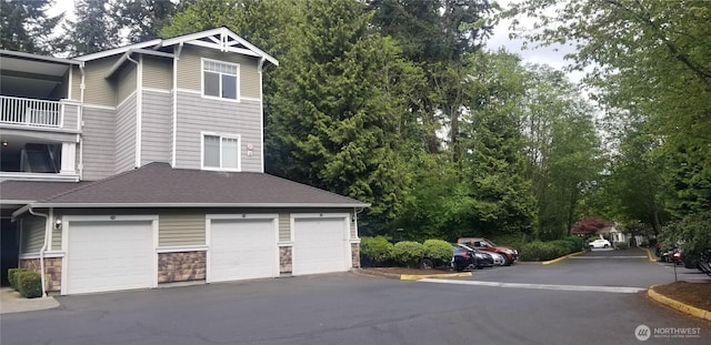 view of side of property featuring stone siding and roof with shingles