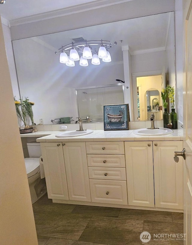 bathroom featuring ornamental molding, toilet, double vanity, and a shower