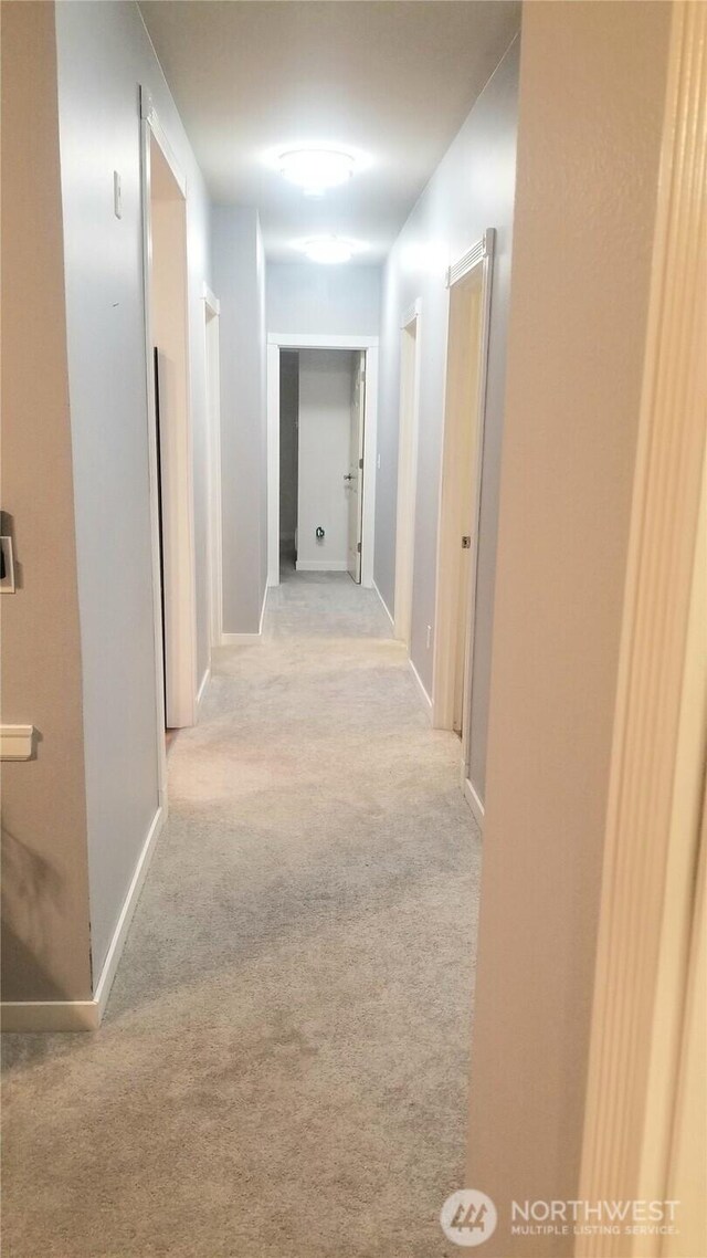 hallway with carpet and baseboards