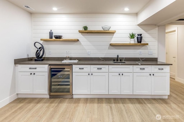 27716 114th Ave E, Graham, WA 98338 - bar featuring light wood finished floors, a sink, visible vents, wet bar, and beverage cooler