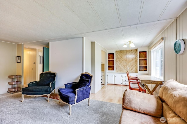living area with built in features, wood finished floors, and wooden walls