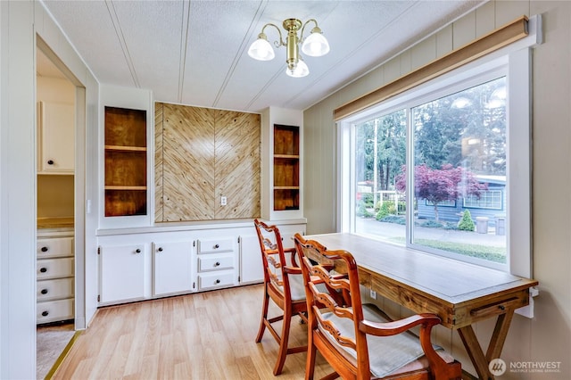 dining room featuring a notable chandelier and light wood-style flooring