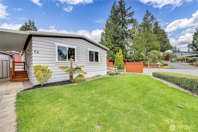 view of home's exterior with fence, an outbuilding, a yard, and a shed