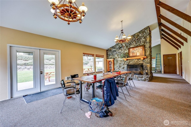 dining area with an inviting chandelier, carpet, french doors, and a fireplace
