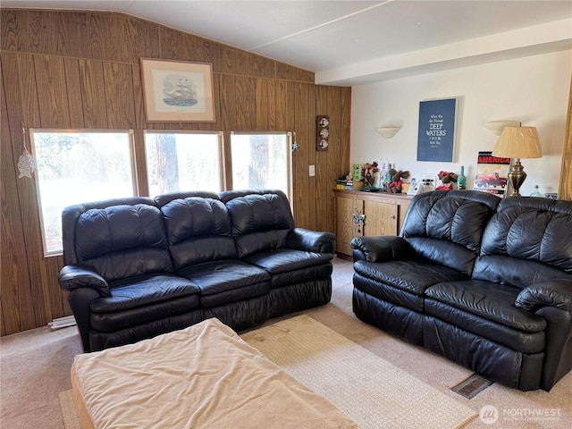 living area featuring wood walls, plenty of natural light, light colored carpet, and vaulted ceiling