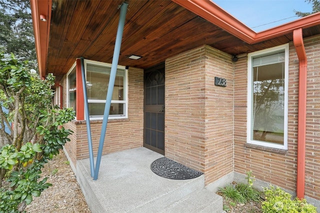 view of exterior entry featuring brick siding
