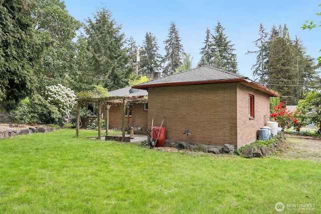 back of house with a lawn and brick siding