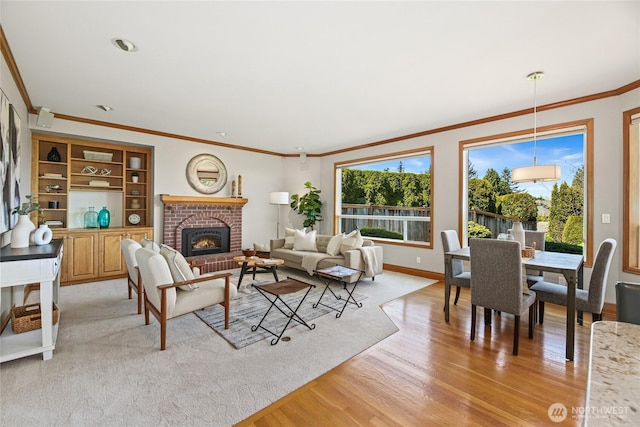 living area featuring baseboards, ornamental molding, light wood-style flooring, and a brick fireplace